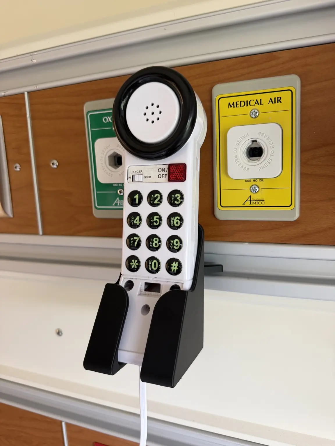 Prototype holder for a hospital room phone