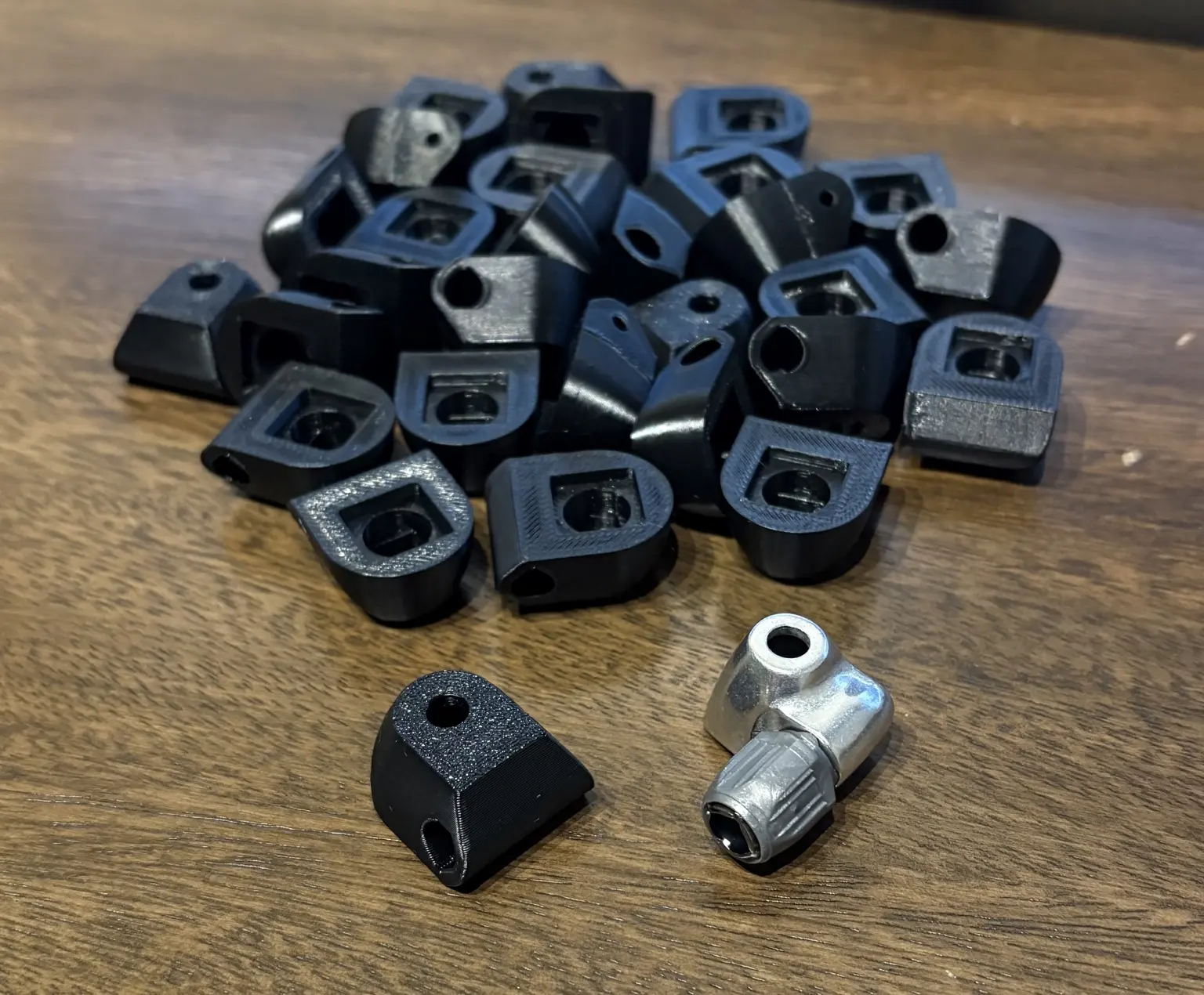 Production run of black shifter cable housing stops beside the original metal component